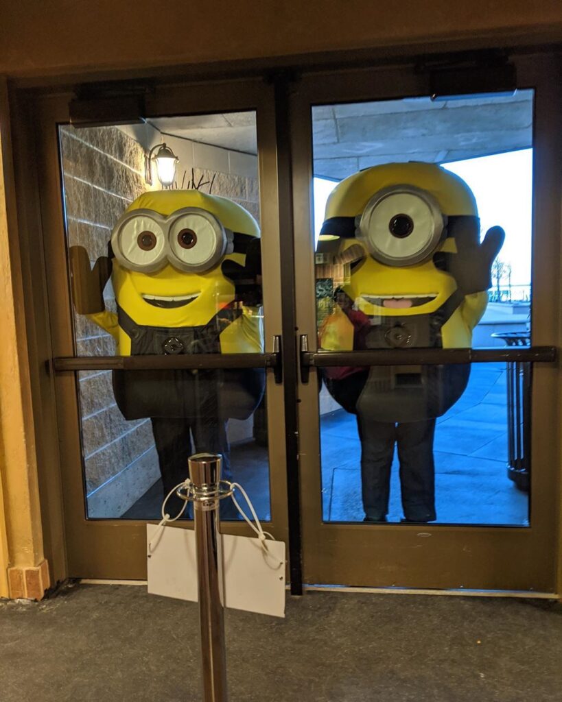 Minions standing outside of a door